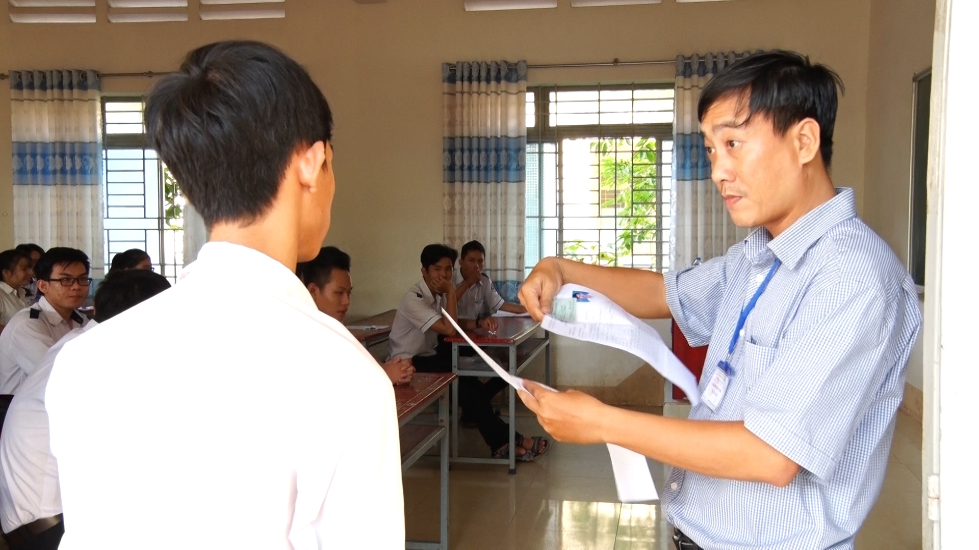 Giám thị kiểm tra các thông tin của thí sinh trước khi vào phòng thi tại điểm thi trường THPT Dầu Giây. Ảnh tư liệu.jpg
