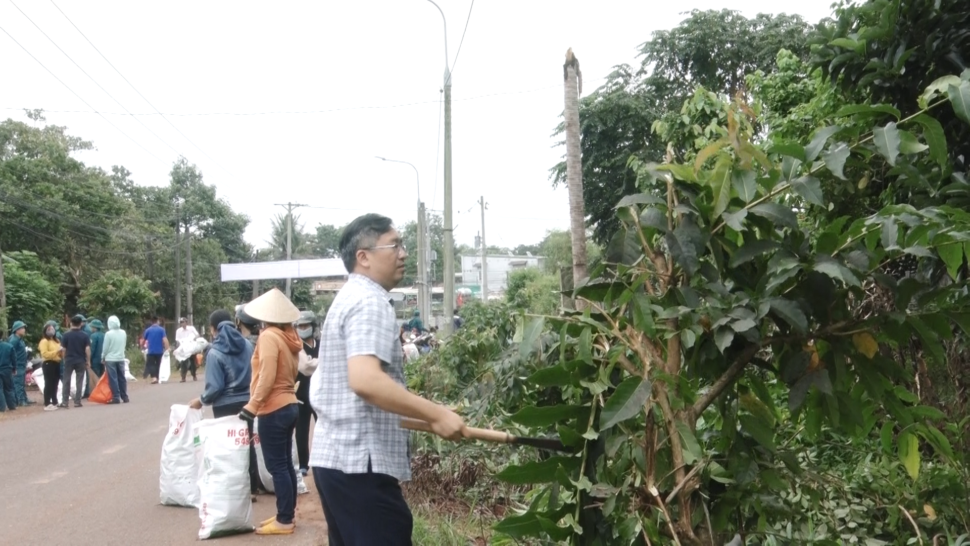 Đồng chí Phạm Hồng Đông Phó Bí thư, Chủ tịch UBND xã tham gia công tác vệ sinh môi trường tại tuyến dường Bến Cá