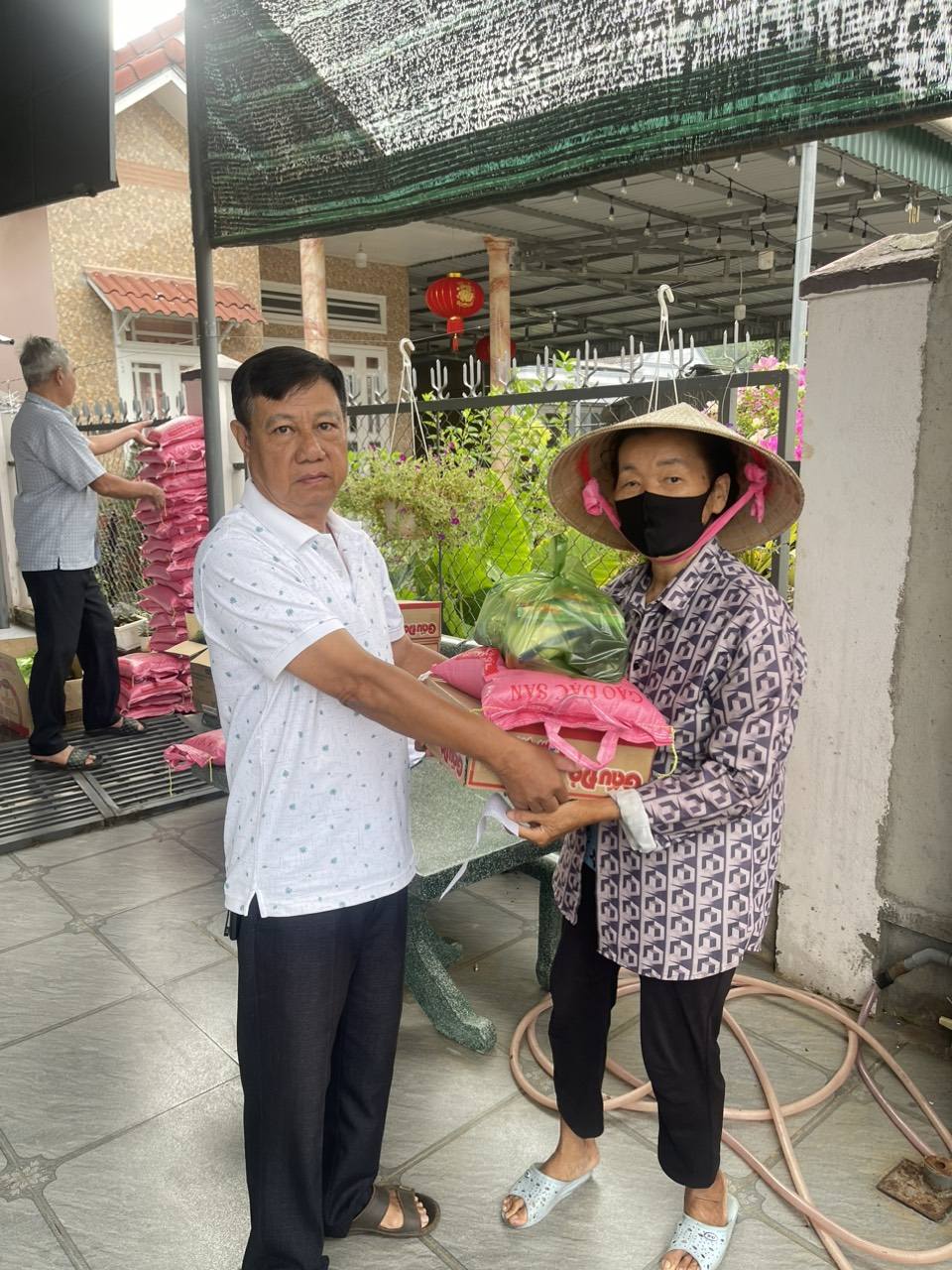 Ông Hoàng Công Huệ Trưởng ấp Cây Xăng trao quà cho các hộ dân có hoàn cảnh khó khăn trên địa bàn ấp